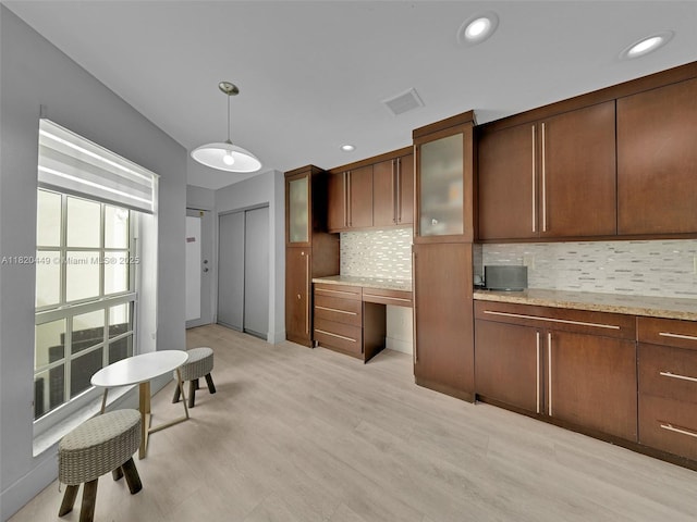 9933 NW 49th Ter, Doral, FL 33178 - kitchen featuring backsplash, built in study area, glass insert cabinets, decorative light fixtures, and recessed lighting