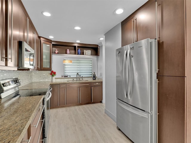 9933 NW 49th Ter, Doral, FL 33178 - kitchen featuring appliances with stainless steel finishes, light wood finished floors, glass insert cabinets, recessed lighting, and light stone countertops
