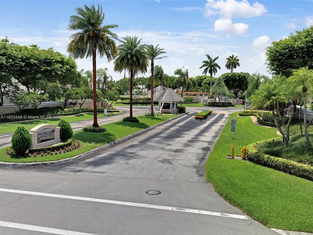9933 NW 49th Ter, Doral, FL 33178 - view of asphalt road with traffic signs, curbs, and a gated entry