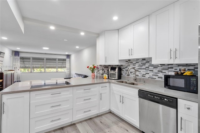215 SE 3rd Ave Unit 303B, Hallandale Beach, FL 33009 - kitchen with black appliances, a peninsula, backsplash, white cabinets, and light wood-type flooring