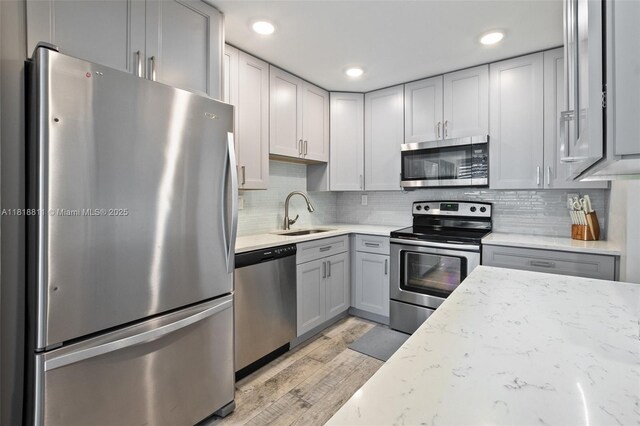 2781 Taft St Unit 308, Hollywood, FL 33020 - kitchen with appliances with stainless steel finishes, light wood-type flooring, tasteful backsplash, light stone counters, and recessed lighting