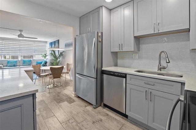 2781 Taft St Unit 308, Hollywood, FL 33020 - kitchen with appliances with stainless steel finishes, gray cabinetry, tasteful backsplash, ceiling fan, and light stone counters
