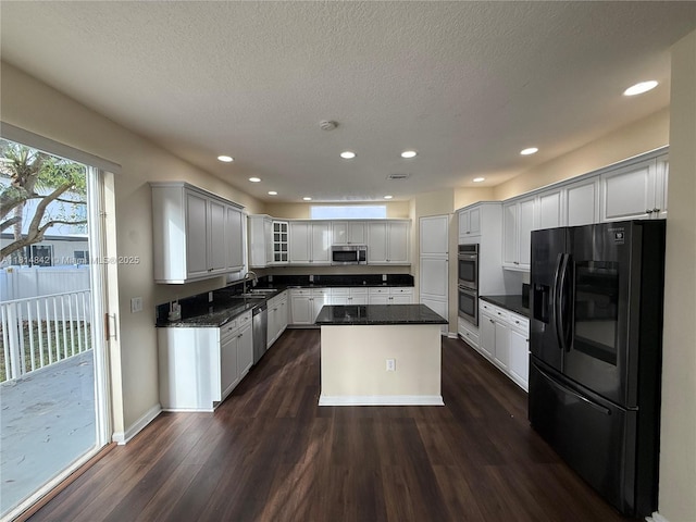 15875 SW 52nd St, Miramar, FL 33027 - kitchen with stainless steel appliances, dark wood-type flooring, a kitchen island, a textured ceiling, and glass insert cabinets