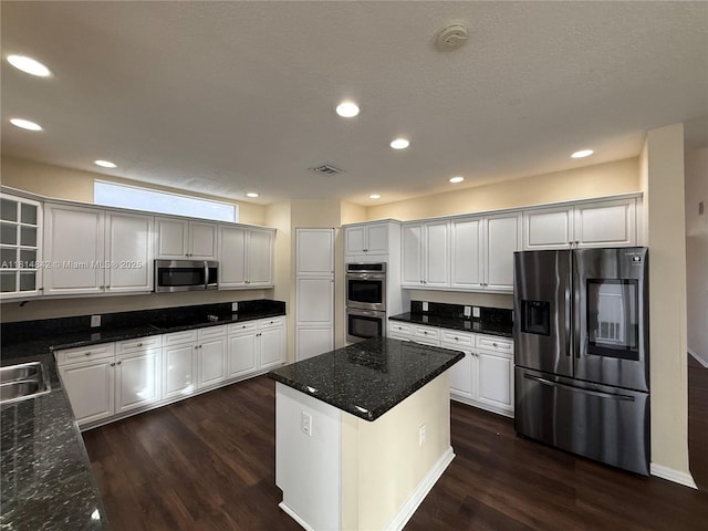 15875 SW 52nd St, Miramar, FL 33027 - kitchen with appliances with stainless steel finishes, dark wood-type flooring, glass insert cabinets, recessed lighting, and a center island