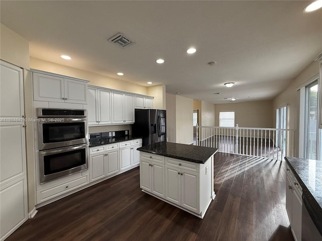 15875 SW 52nd St, Miramar, FL 33027 - kitchen featuring appliances with stainless steel finishes, dark wood-style floors, a kitchen island, recessed lighting, and white cabinets