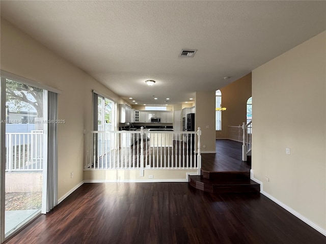 15875 SW 52nd St, Miramar, FL 33027 - unfurnished living room with dark wood-style floors, a textured ceiling, and arched walkways