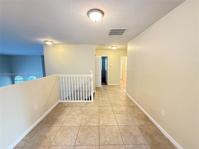 15875 SW 52nd St, Miramar, FL 33027 - hallway featuring a textured ceiling, an upstairs landing, and light tile patterned floors