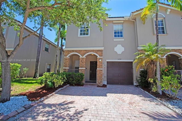 22569 SW 89th Pl, Cutler Bay, FL 33190 - view of front facade featuring an attached garage, stucco siding, decorative driveway, stone siding, and a tiled roof
