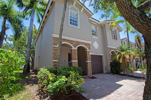 22569 SW 89th Pl, Cutler Bay, FL 33190 - mediterranean / spanish home with stucco siding, an attached garage, stone siding, and driveway