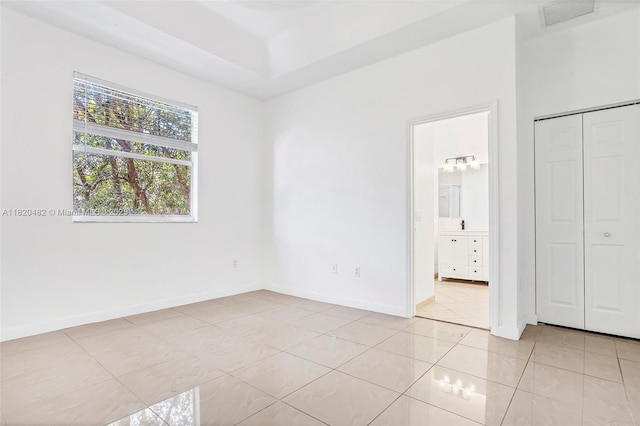 22569 SW 89th Pl, Cutler Bay, FL 33190 - unfurnished bedroom featuring light tile patterned floors, ensuite bathroom, and a closet
