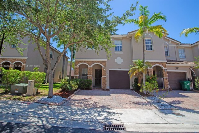 22569 SW 89th Pl, Cutler Bay, FL 33190 - mediterranean / spanish-style home featuring stone siding, an attached garage, driveway, and stucco siding