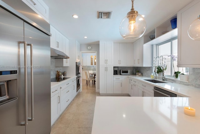 11900 SW 72nd Pl, Pinecrest, FL 33156 - kitchen with appliances with stainless steel finishes, under cabinet range hood, tasteful backsplash, white cabinets, and light countertops