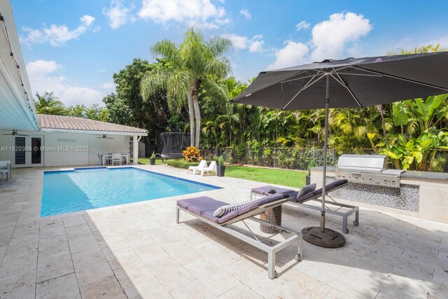 11900 SW 72nd Pl, Pinecrest, FL 33156 - view of pool with a ceiling fan, an outdoor kitchen, and a patio