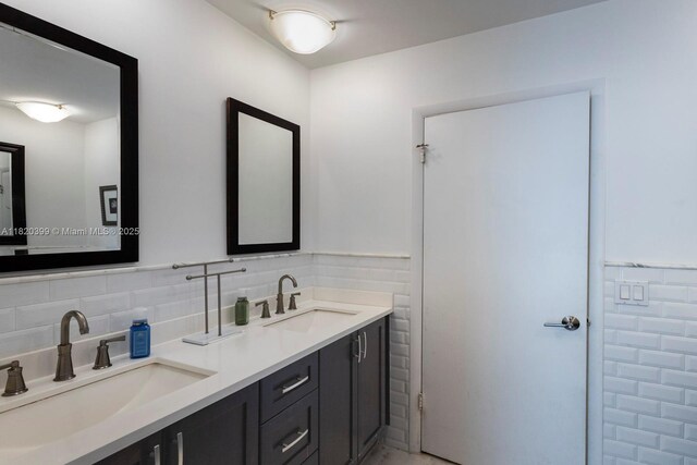 11900 SW 72nd Pl, Pinecrest, FL 33156 - bathroom featuring double vanity, tile walls, and tasteful backsplash