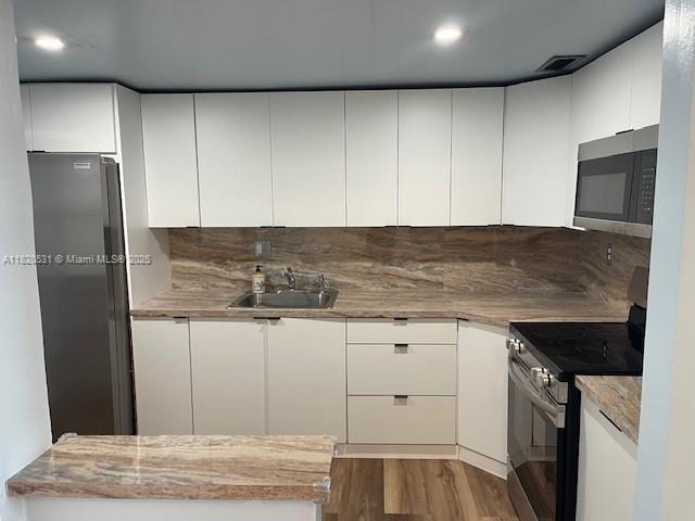 1475 NE 125th Ter Unit 614K, North Miami, FL 33161 - kitchen featuring stainless steel appliances, dark wood-style floors, white cabinetry, recessed lighting, and tasteful backsplash