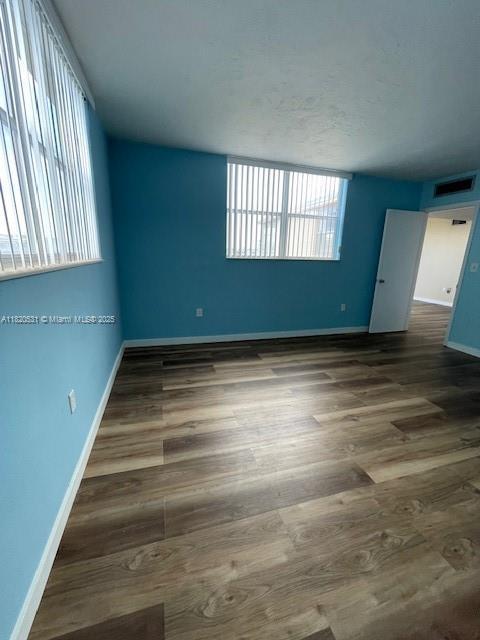 1475 NE 125th Ter Unit 614K, North Miami, FL 33161 - unfurnished room with baseboards and wood finished floors