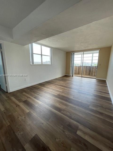 1475 NE 125th Ter Unit 614K, North Miami, FL 33161 - spare room featuring dark wood-type flooring and baseboards