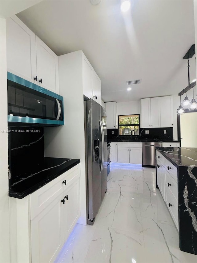543 E 61st St, Hialeah, FL 33013 - kitchen with appliances with stainless steel finishes, light marble finish flooring, white cabinets, pendant lighting, and dark stone counters