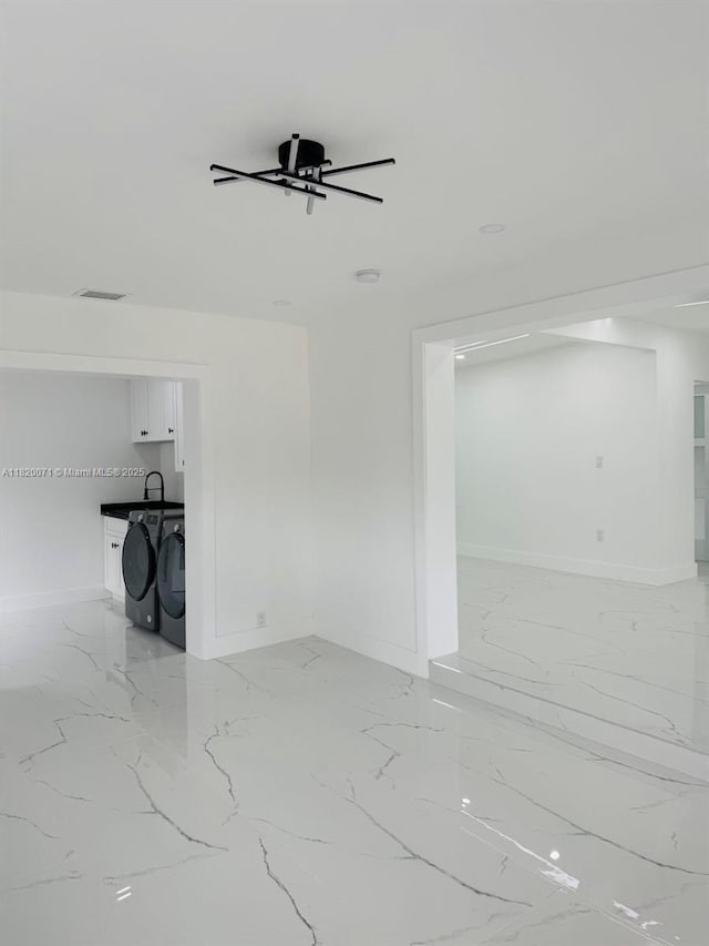 543 E 61st St, Hialeah, FL 33013 - unfurnished living room featuring light marble finish floors, washing machine and clothes dryer, and a ceiling fan