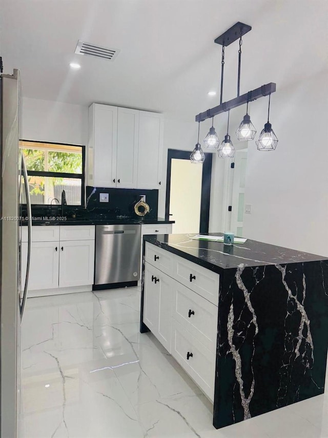 543 E 61st St, Hialeah, FL 33013 - kitchen featuring light marble finish floors, dishwasher, white cabinetry, freestanding refrigerator, and decorative light fixtures