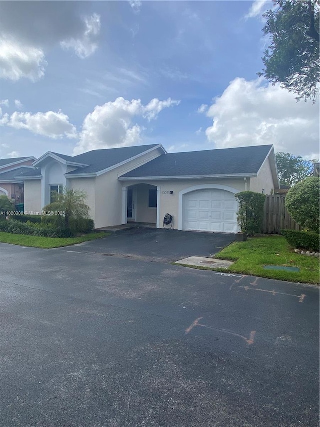 10090 NW 57th St, Doral, FL 33178 - ranch-style house featuring stucco siding, an attached garage, and driveway