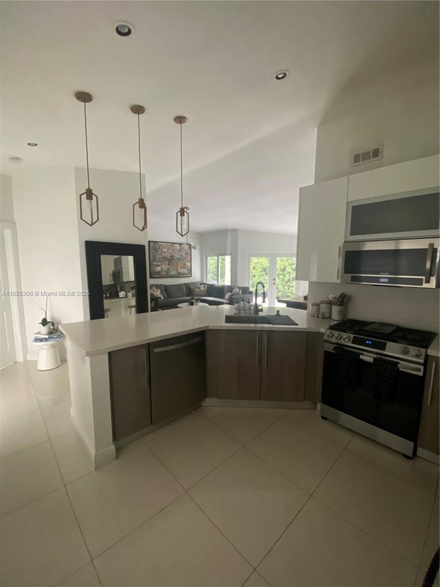 10090 NW 57th St, Doral, FL 33178 - kitchen with stainless steel appliances, open floor plan, modern cabinets, hanging light fixtures, and light tile patterned flooring