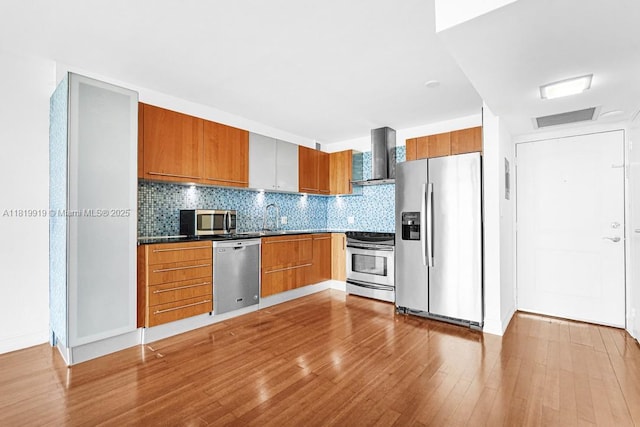 100 Bayview Dr Unit 1223, Sunny Isles Beach, FL 33160 - kitchen featuring appliances with stainless steel finishes, wall chimney exhaust hood, wood finished floors, and tasteful backsplash