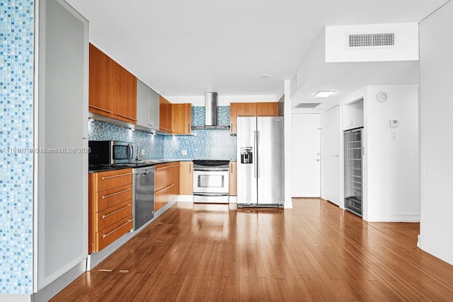 100 Bayview Dr Unit 1223, Sunny Isles Beach, FL 33160 - kitchen with stainless steel appliances, wall chimney exhaust hood, brown cabinetry, beverage cooler, and dark wood-style floors