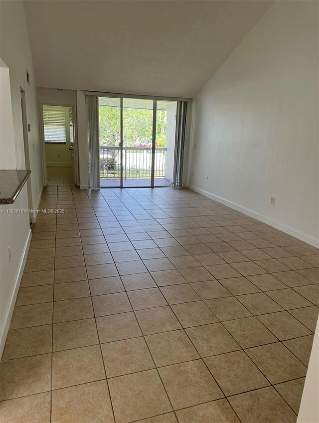 4659 NW 97th Ct Unit 35, Doral, FL 33178 - empty room with light tile patterned floors and vaulted ceiling