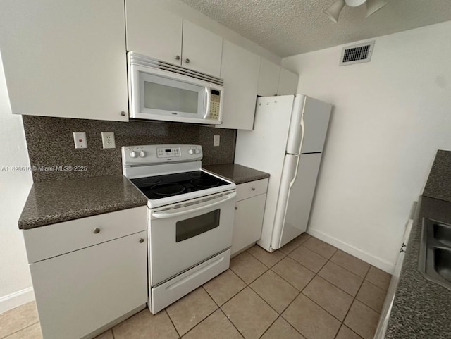 4659 NW 97th Ct Unit 35, Doral, FL 33178 - kitchen with white appliances, dark countertops, tasteful backsplash, white cabinetry, and a textured ceiling