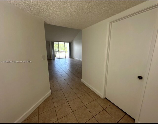 4659 NW 97th Ct Unit 35, Doral, FL 33178 - corridor with light tile patterned floors, a textured ceiling, and vaulted ceiling