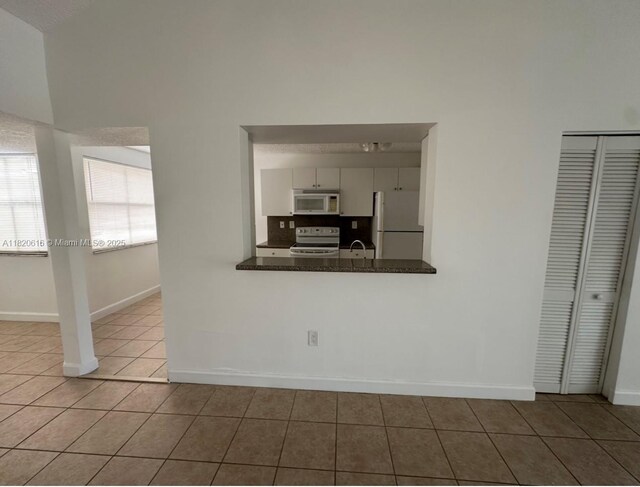 4659 NW 97th Ct Unit 35, Doral, FL 33178 - unfurnished living room featuring tile patterned flooring and baseboards