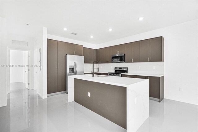 28841 SW 162nd Ave Unit A, Miami, FL 33033 - kitchen featuring stainless steel appliances, dark brown cabinetry, a kitchen island with sink, modern cabinets, and light countertops