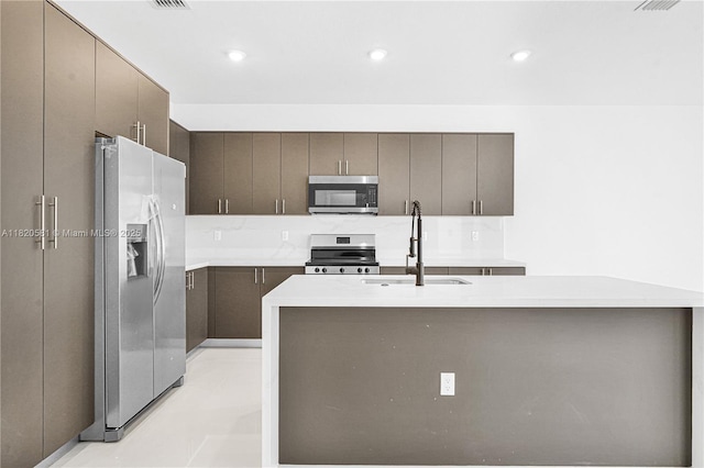 28841 SW 162nd Ave Unit A, Miami, FL 33033 - kitchen featuring appliances with stainless steel finishes, light countertops, dark brown cabinets, recessed lighting, and an island with sink