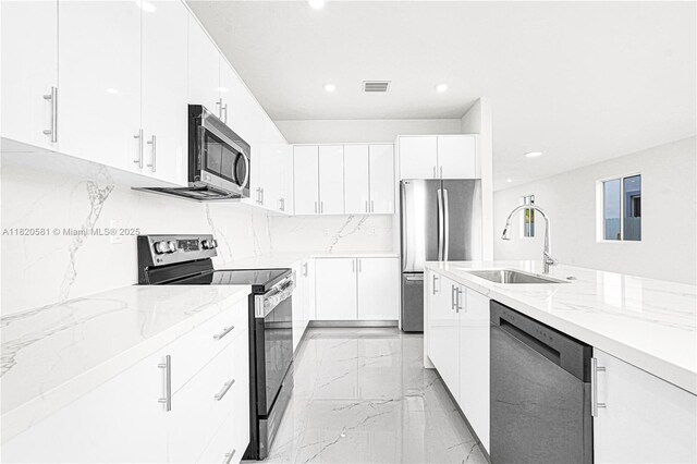 28841 SW 162nd Ave Unit A, Miami, FL 33033 - kitchen with appliances with stainless steel finishes, light marble finish flooring, light stone countertops, white cabinets, and recessed lighting