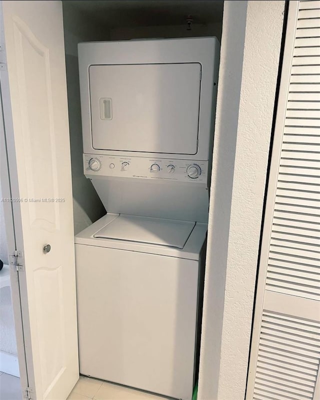 445 SW 11th St Unit 101, Miami, FL 33130 - laundry area with estacked washer and dryer and light tile patterned floors