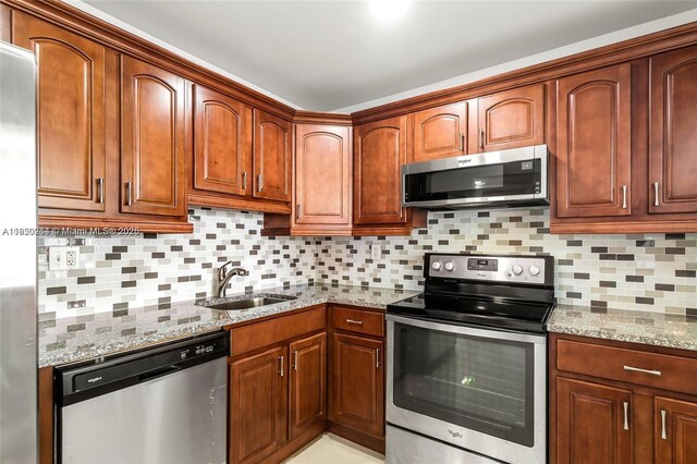 7118 Bonita Dr Unit 405, Miami Beach, FL 33141 - kitchen with stainless steel appliances, light stone countertops, and tasteful backsplash