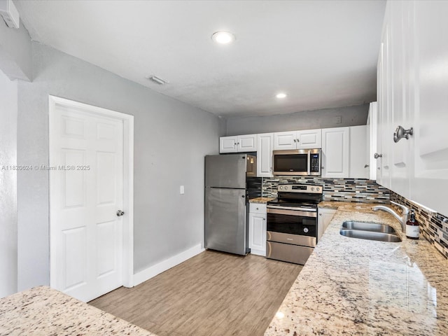 1805 N 23rd Ave, Hollywood, FL 33020 - kitchen with appliances with stainless steel finishes, tasteful backsplash, light wood-style flooring, white cabinets, and recessed lighting