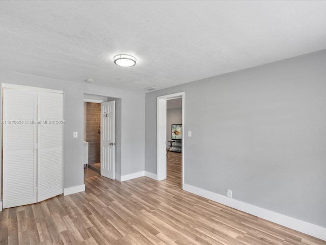 1805 N 23rd Ave, Hollywood, FL 33020 - unfurnished bedroom featuring light wood-type flooring, a closet, and a textured ceiling