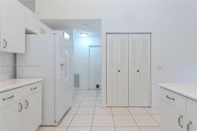 16176 NW 14th Ct, Pembroke Pines, FL 33028 - kitchen with white refrigerator with ice dispenser, light tile patterned flooring, light countertops, and white cabinets
