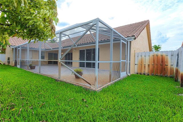 16176 NW 14th Ct, Pembroke Pines, FL 33028 - back of property with a fenced backyard, a tiled roof, a patio, stucco siding, and a lanai