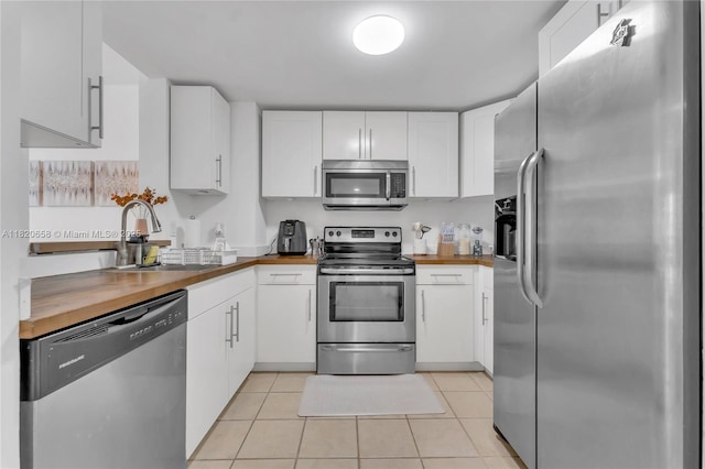 1250 S Miami Ave Unit 2210, Miami, FL 33130 - kitchen featuring stainless steel appliances, butcher block countertops, light tile patterned flooring, and white cabinets
