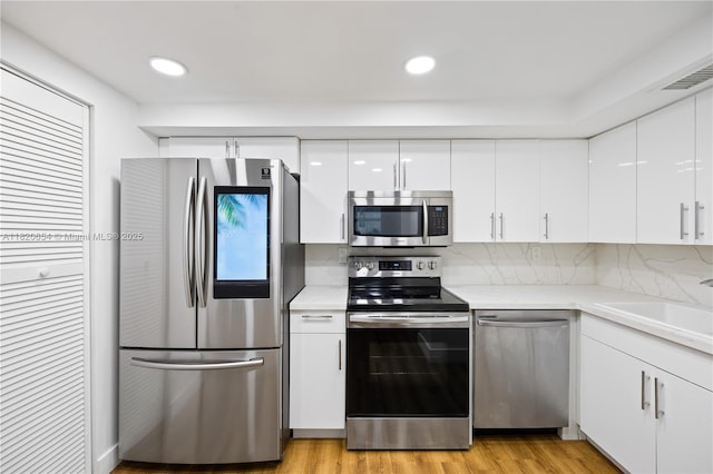 1440 Brickell Bay Unit 307, Miami, FL 33131 - kitchen with appliances with stainless steel finishes, white cabinets, light countertops, modern cabinets, and recessed lighting
