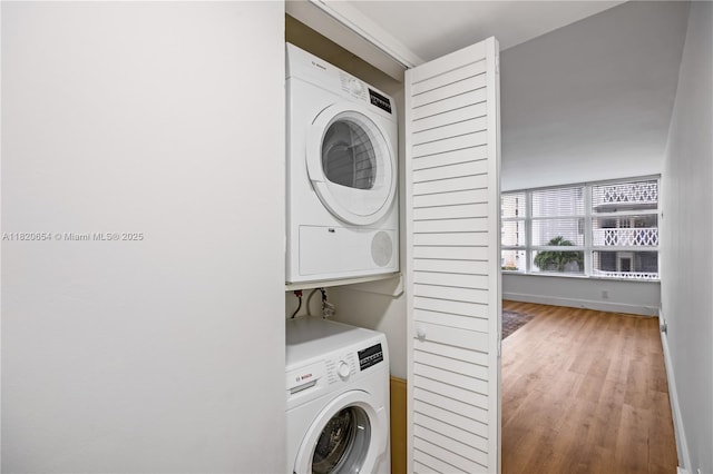 1440 Brickell Bay Unit 307, Miami, FL 33131 - laundry room with stacked washer and clothes dryer and wood finished floors