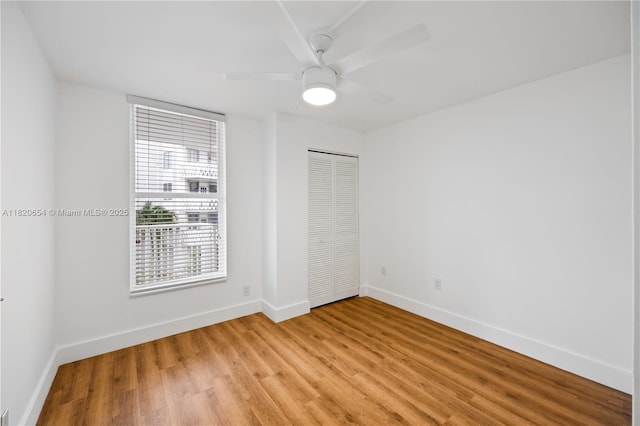1440 Brickell Bay Unit 307, Miami, FL 33131 - unfurnished bedroom with light wood-style floors, a closet, and a ceiling fan