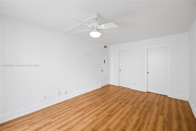 1440 Brickell Bay Unit 307, Miami, FL 33131 - unfurnished bedroom with light wood-style flooring, ceiling fan, and multiple closets