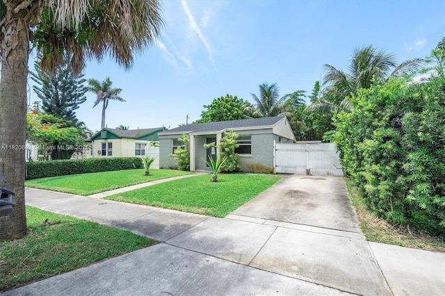 602 El Prado, West Palm Beach, FL 33405 - view of front of house featuring a gate, a front lawn, concrete driveway, and stucco siding