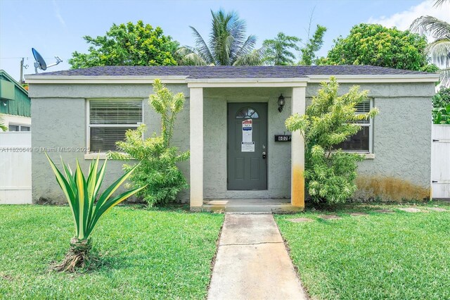602 El Prado, West Palm Beach, FL 33405 - doorway to property featuring a lawn and stucco siding