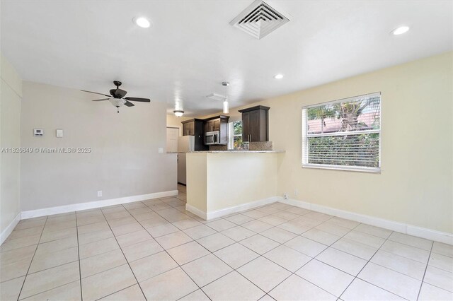 602 El Prado, West Palm Beach, FL 33405 - kitchen featuring stainless steel microwave, a peninsula, a ceiling fan, recessed lighting, and freestanding refrigerator