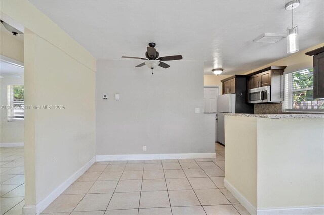 602 El Prado, West Palm Beach, FL 33405 - kitchen with stainless steel microwave, a ceiling fan, dark brown cabinets, and light tile patterned flooring